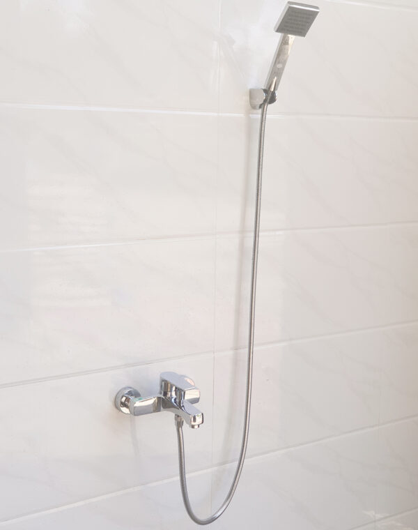 Hình ảnh củ sen nóng lạnh Eurolife EL-JAS 01 lắp đặt hoàn chỉnh cùng tay sen, dây sen 150cm và bát gác trên tường phòng tắm.